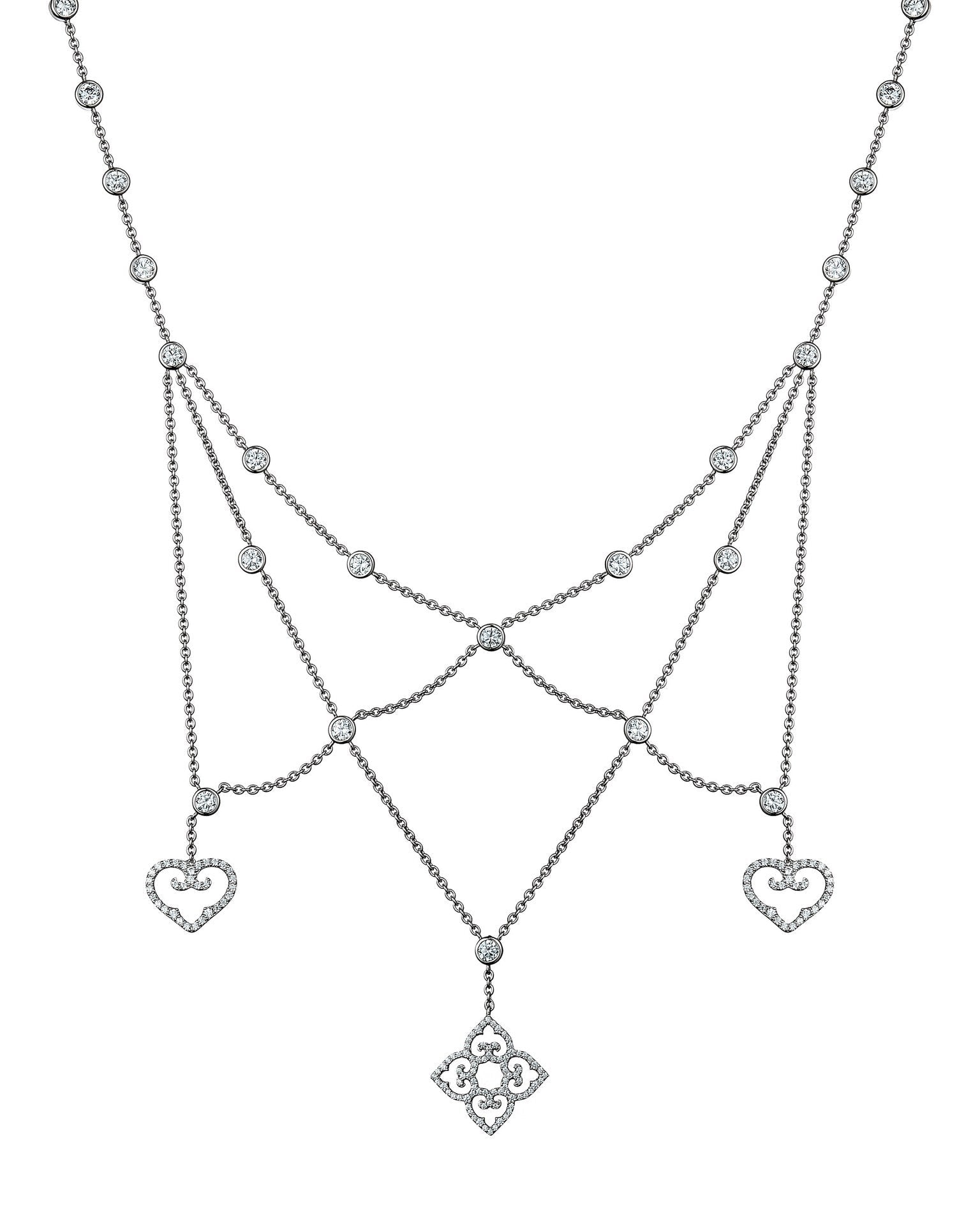 Silver necklace with heart and floral pendant on a white background