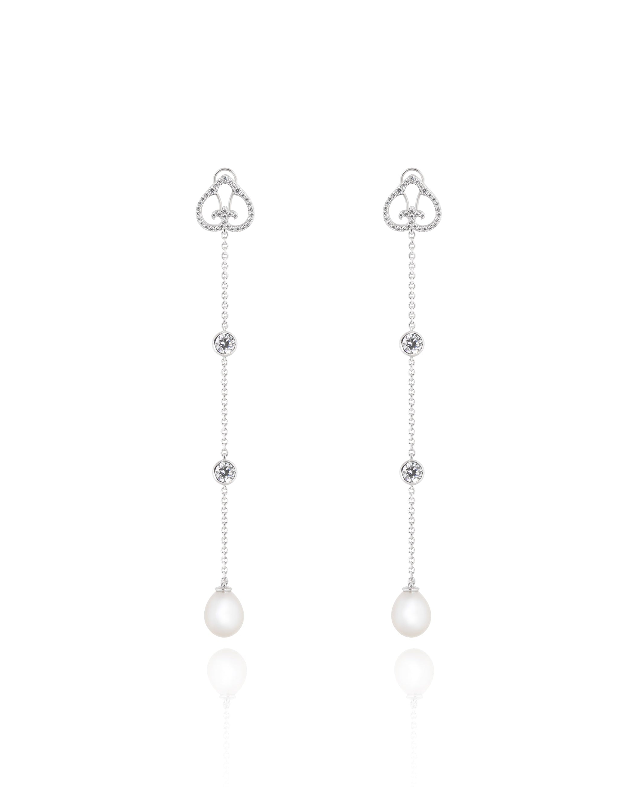 Pair of silver earrings with heart-shaped tops and pearl drops on a white background