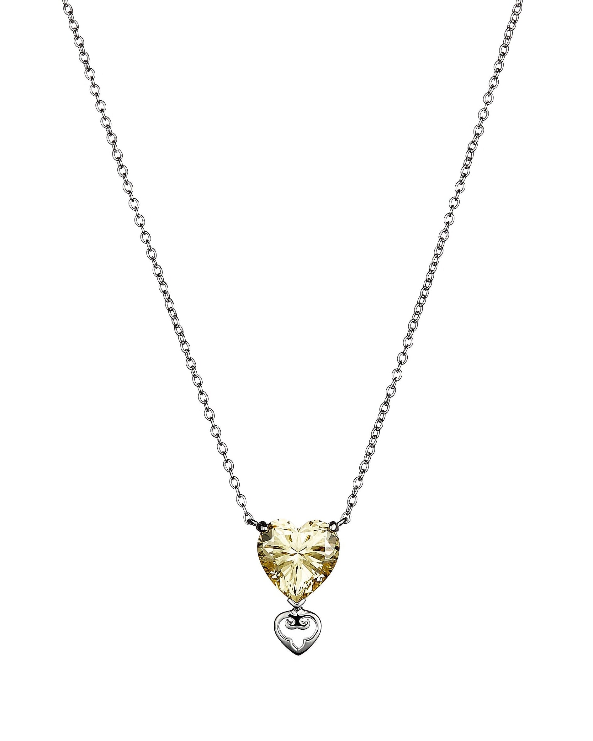 Heart-shaped pendant necklace with a yellow gemstone on a white background